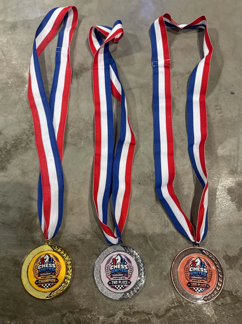 The champion, second-place and third-place medals for Chess United Tournament 1.0, with red, white and blue ribbons.